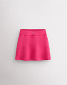 Back view of dreamhouse pink girls ruffle tennis skirt showing layered ruffle detail, elastic waistband, and Stelle logo.