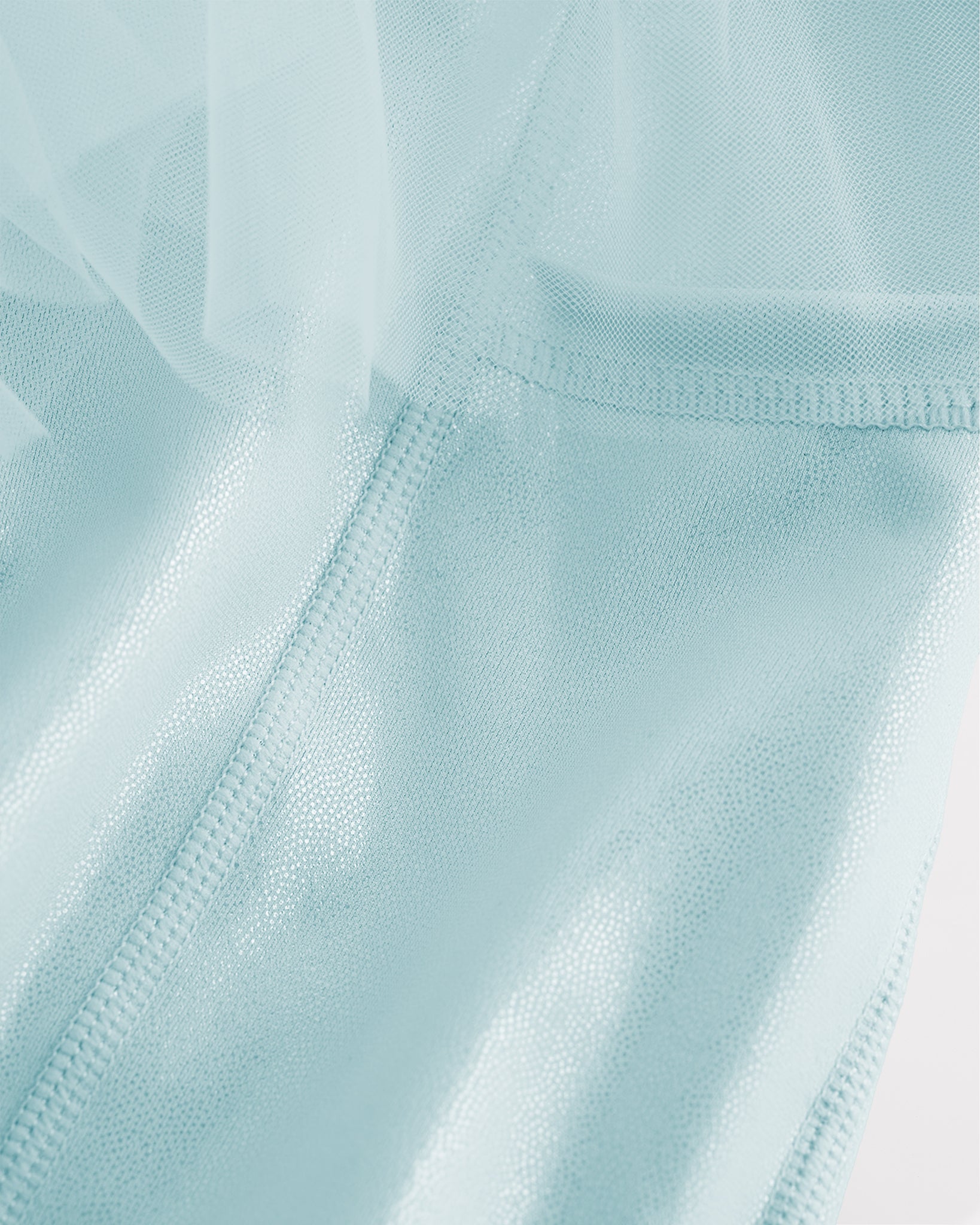 Close-up of light blue skort for girls showing sheer tiered mesh and shiny built-in shorts.