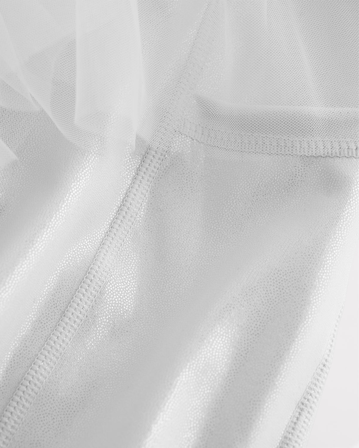 Close-up of white skort for girls showing sheer tiered mesh and shiny built-in shorts.