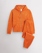 Orange Stelle kids velour tracksuit set with full-zip hoodie and matching joggers, laid flat on a grey background.