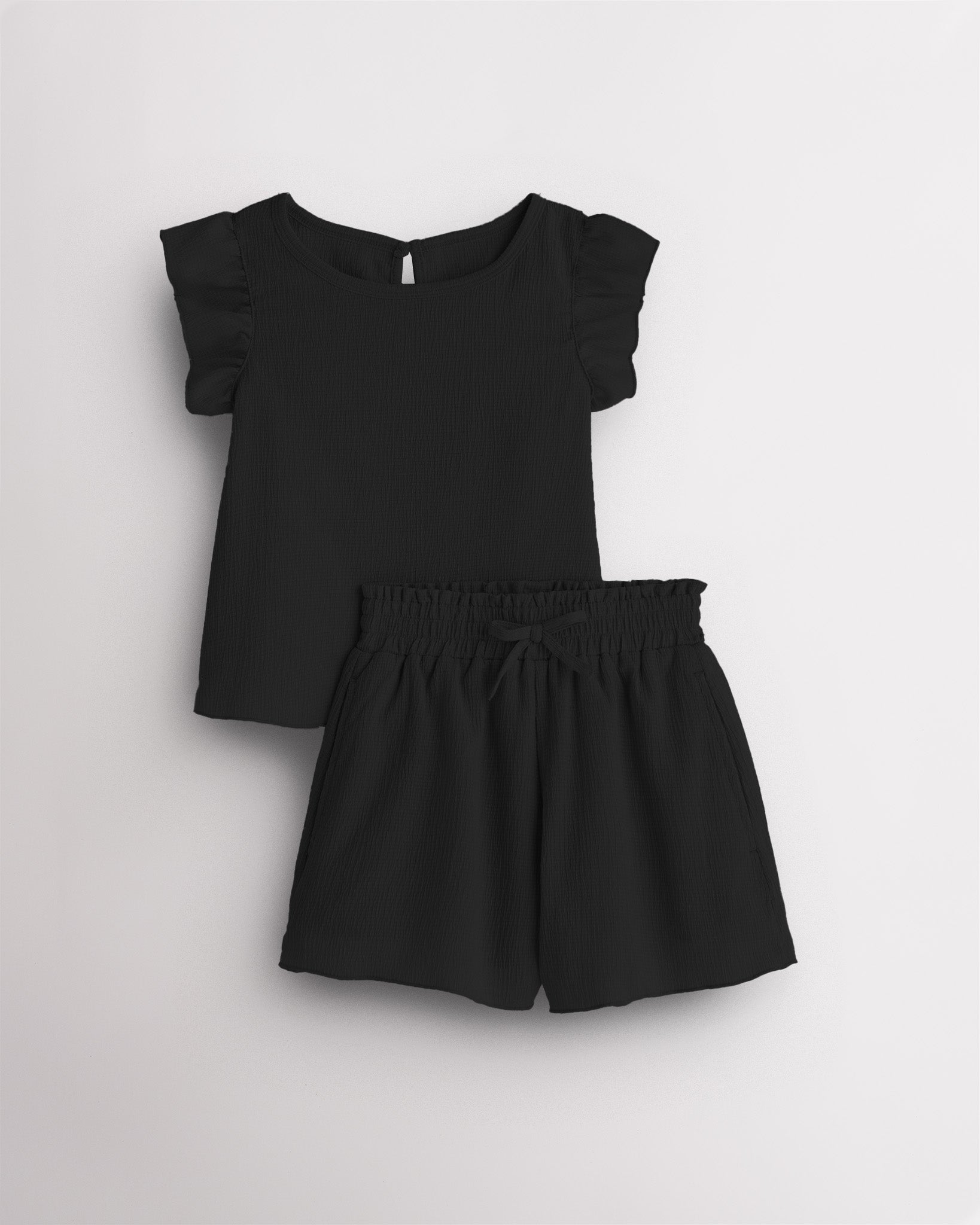 Girls black flutter sleeve summer outfit set with textured top, button-back detail, and matching elastic waist shorts with bow.