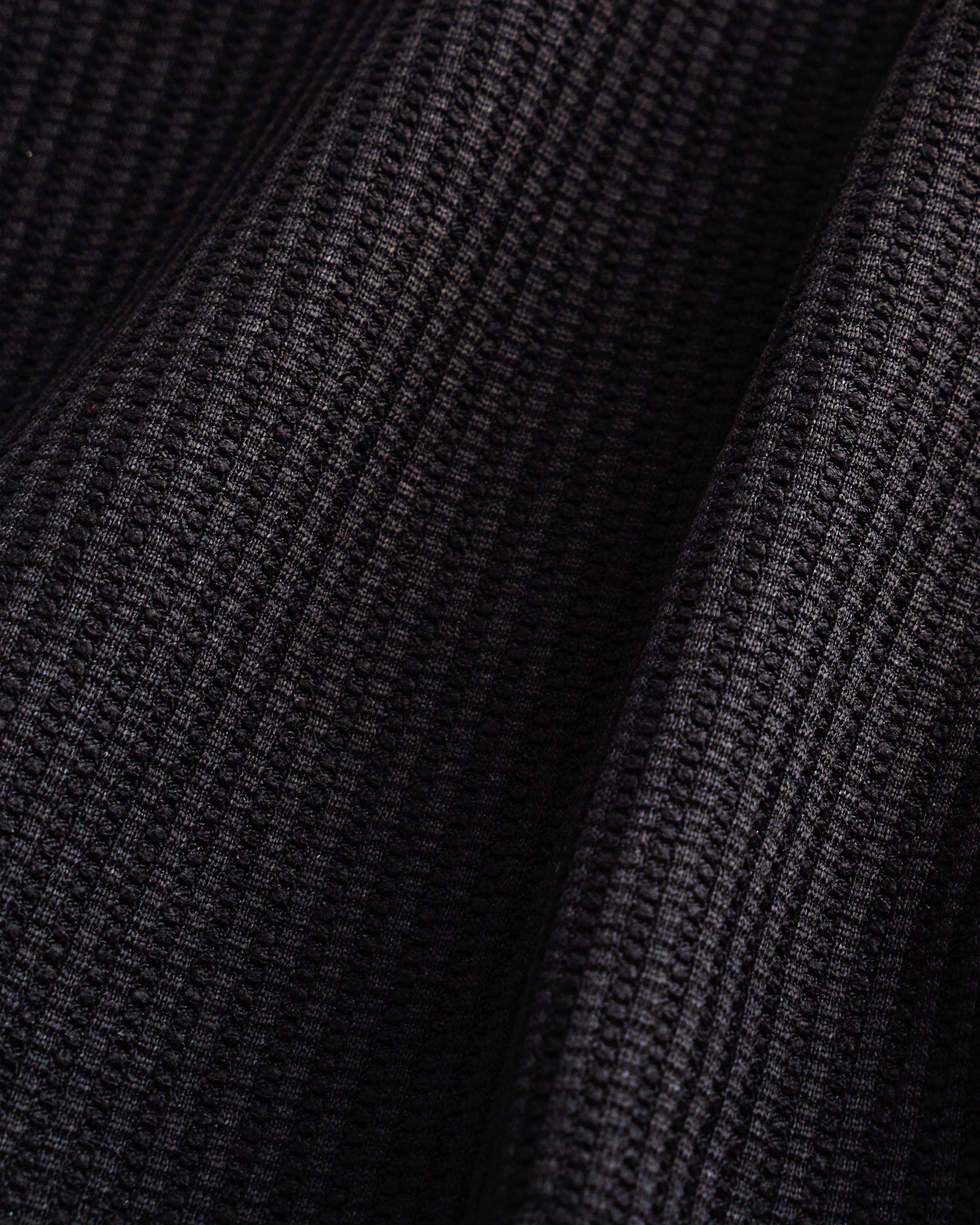 Close-up of the black waffle knit texture on the Stelle kids lounge set.