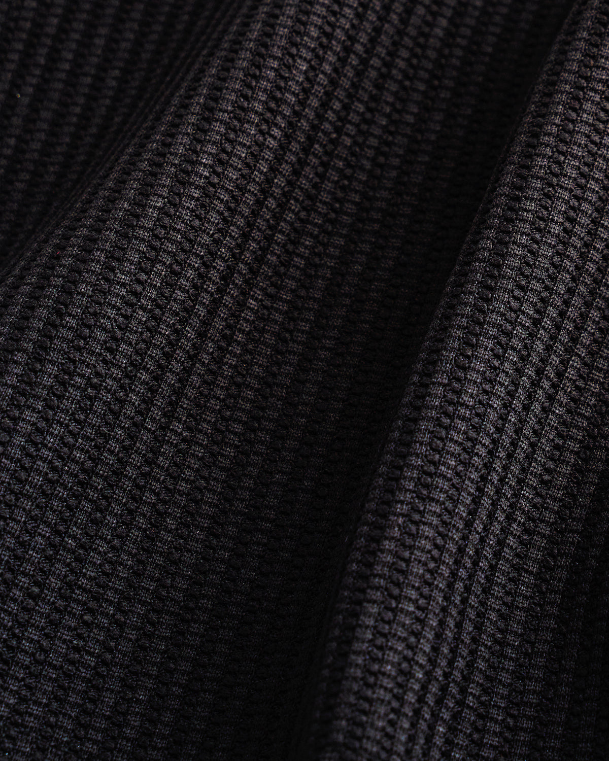 Close-up of the black waffle knit texture on the Stelle kids lounge set.