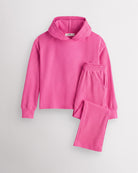 Dreamhouse Pink Stelle kids waffle knit lounge set with a hooded top and matching pants, laid flat on a grey background.