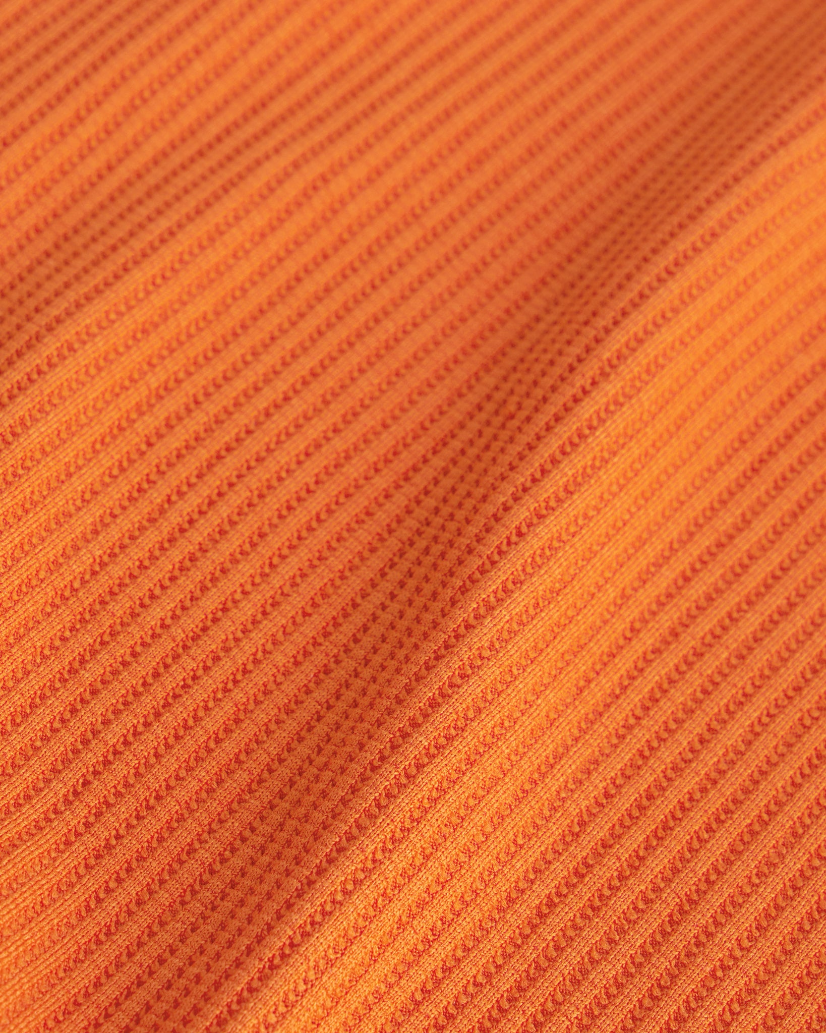 Close-up of the orange waffle knit texture on the Stelle kids lounge set.