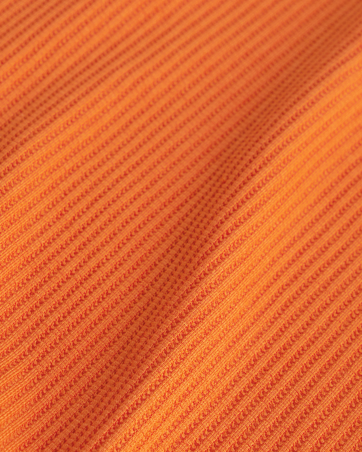 Close-up of the orange waffle knit texture on the Stelle kids lounge set.