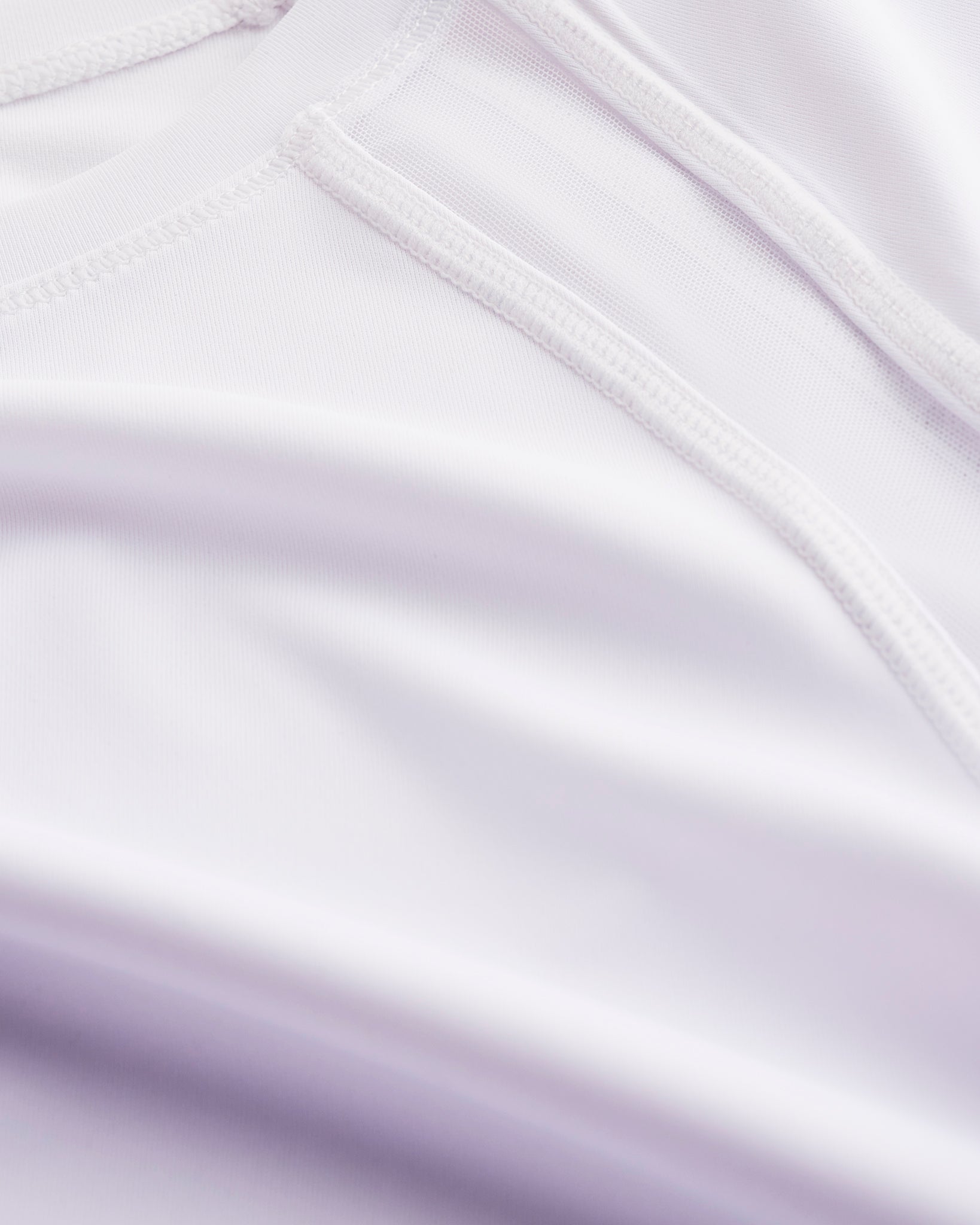 Close-up of Stelle kids ombre athletic t-shirt showing white mesh paneling, smooth seams, and lavender gradient fabric.