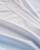 Close-up of Stelle kids ombre athletic t-shirt showing white mesh paneling, smooth seams, and light blue gradient fabric.