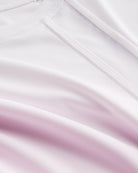 Close-up of Stelle kids ombre athletic t-shirt showing white mesh paneling, smooth seams, and pink gradient fabric.