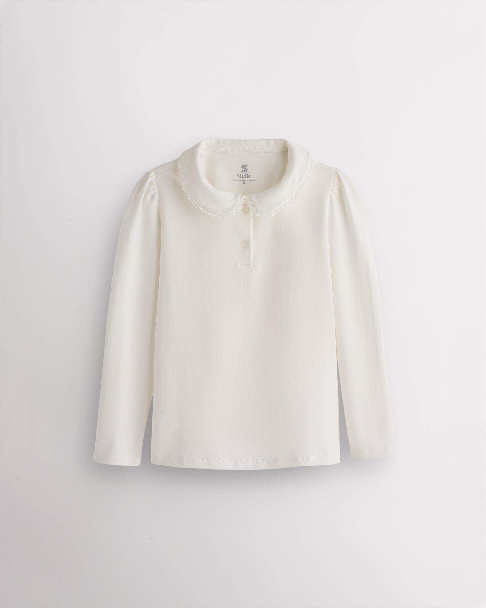 White girls Peter Pan collar long sleeve top with lace trim, subtle puffed shoulders, and two-button placket.