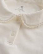 Close-up of white girls Peter Pan collar top showing delicate lace trim, button placket, and soft fabric.