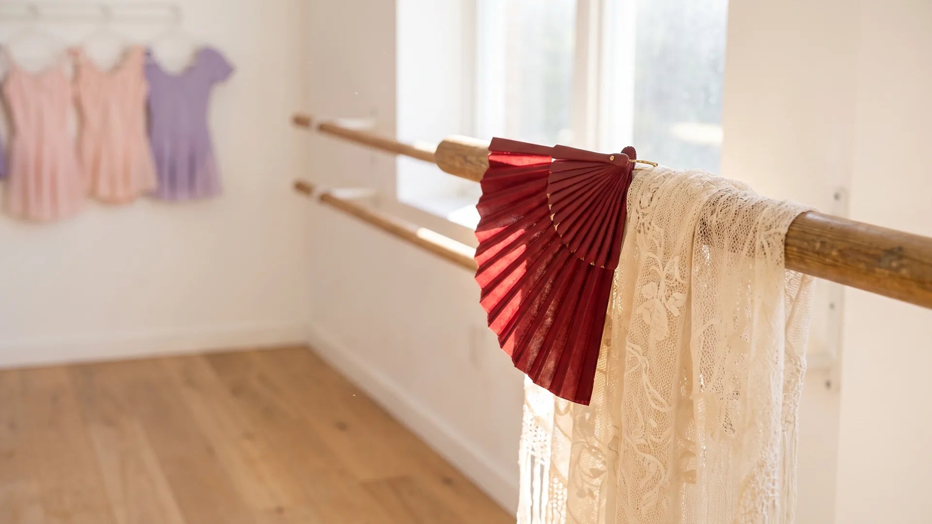 Red fan and lace shawl on a ballet barre evoking Don Quixote's Spanish setting