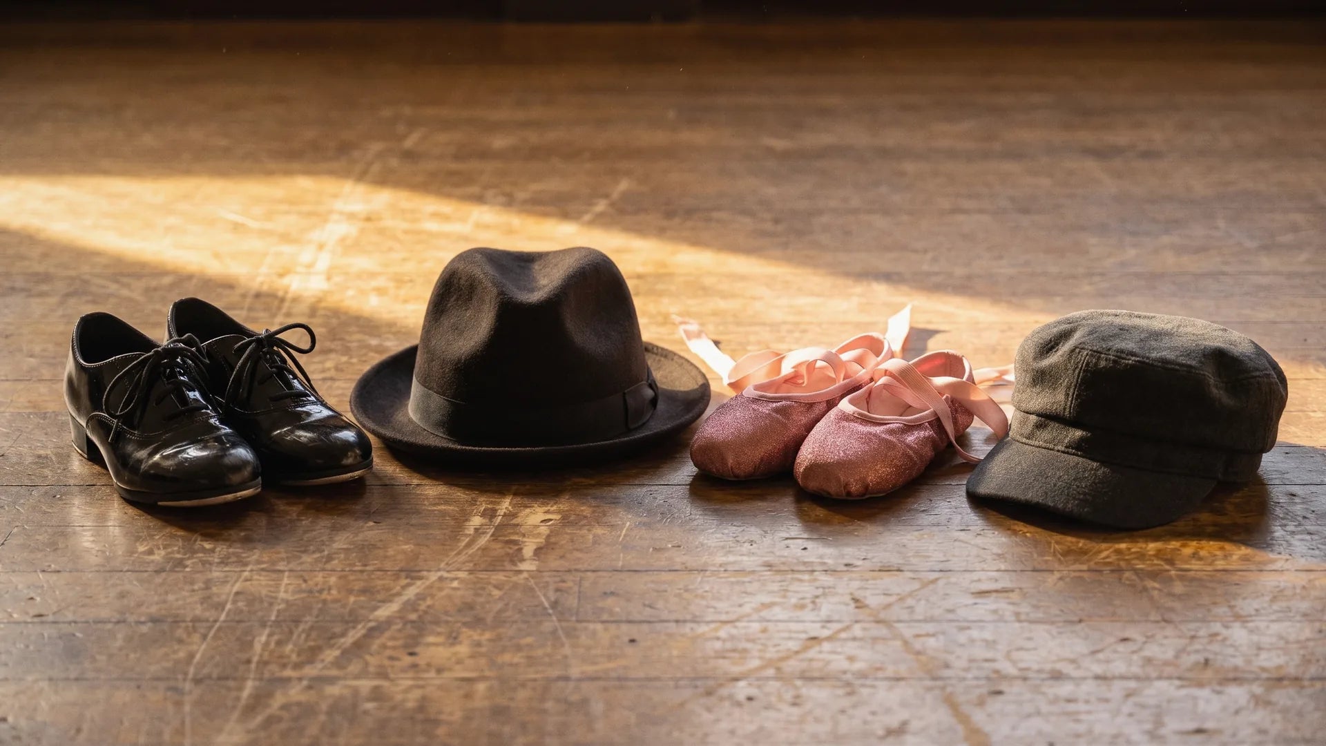 Tap shoes, pointe shoes, fedora and cap representing famous dancers across styles