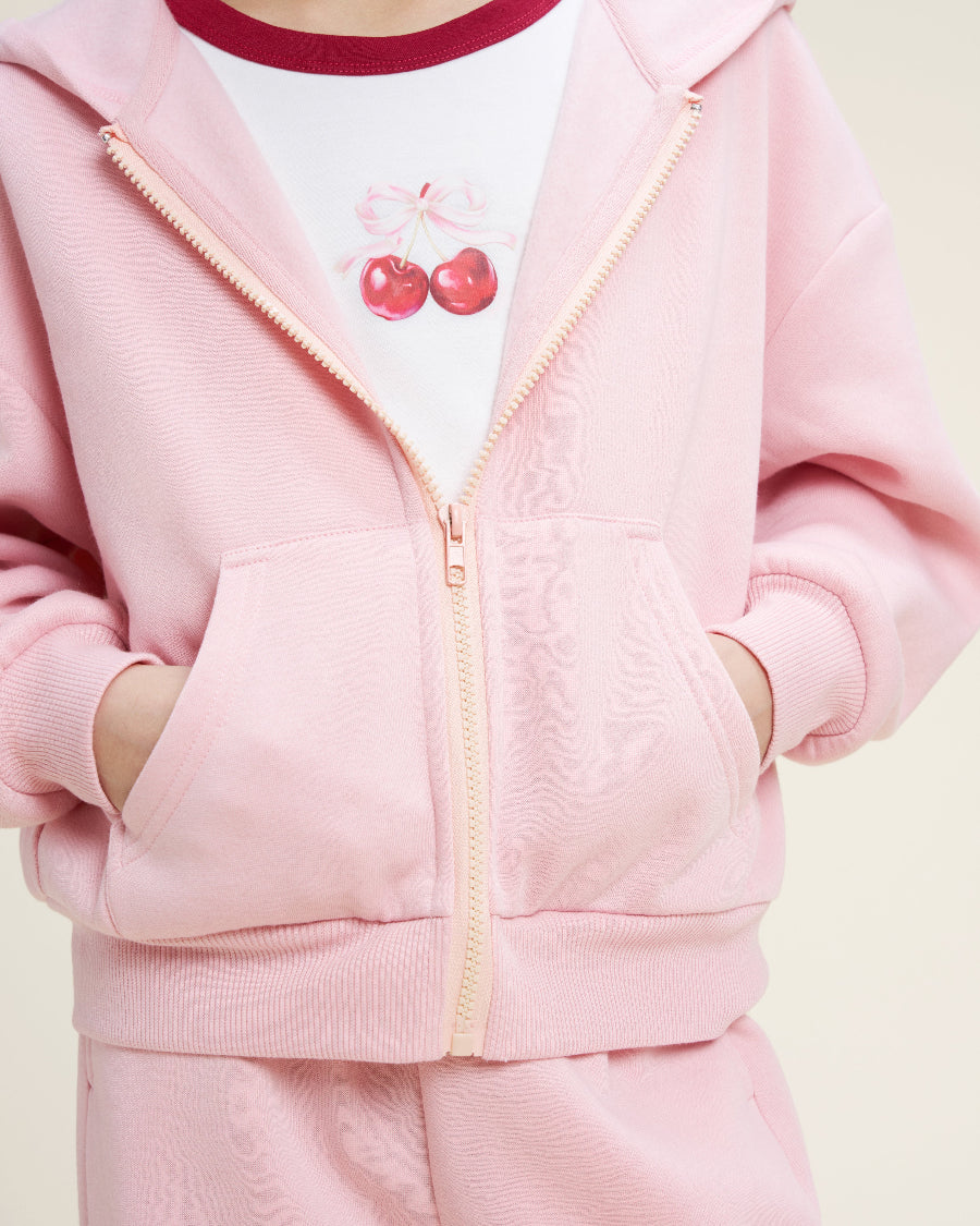 Pink tracksuit with cherry design on a white background